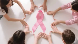 Group of friends forming a pink cancer-support ribbon with their hands