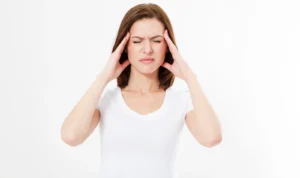Woman pressing her temples while experiencing a migraine