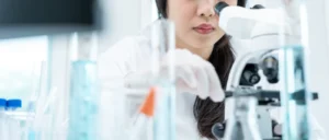 Scientist examining samples through a laboratory microscope