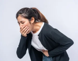 Woman experiencing nausea and holding her stomach