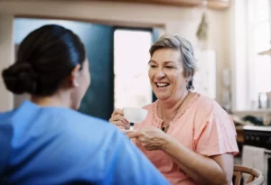 Caregiver talking with a senior woman at home